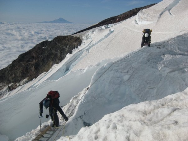 Climbers crossing a crevasse on Mount Rainier
